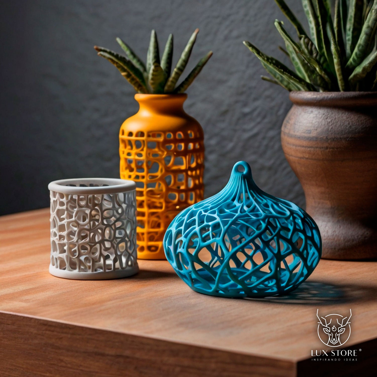 Imagen de varios objetos decorativos impresos en 3D, exhibidos sobre una superficie de madera. Los diseños incluyen una estructura cilíndrica blanca, un recipiente esférico azul con patrones intrincados, y un jarrón naranja con detalles geométricos.